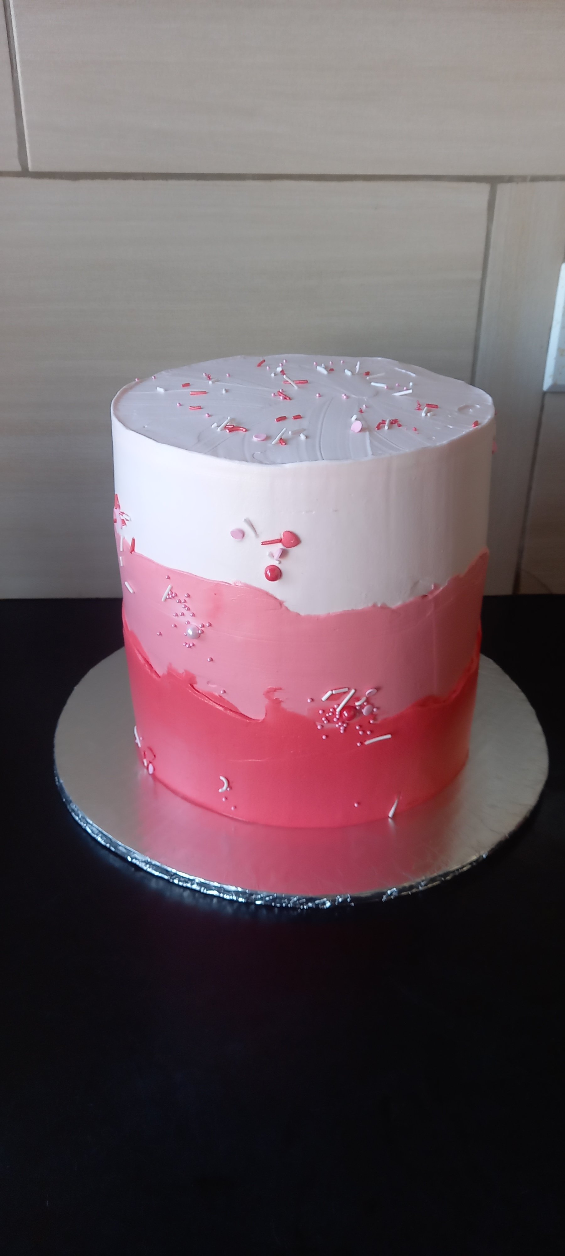 Pink and red ombre buttercream cake with sprinkles