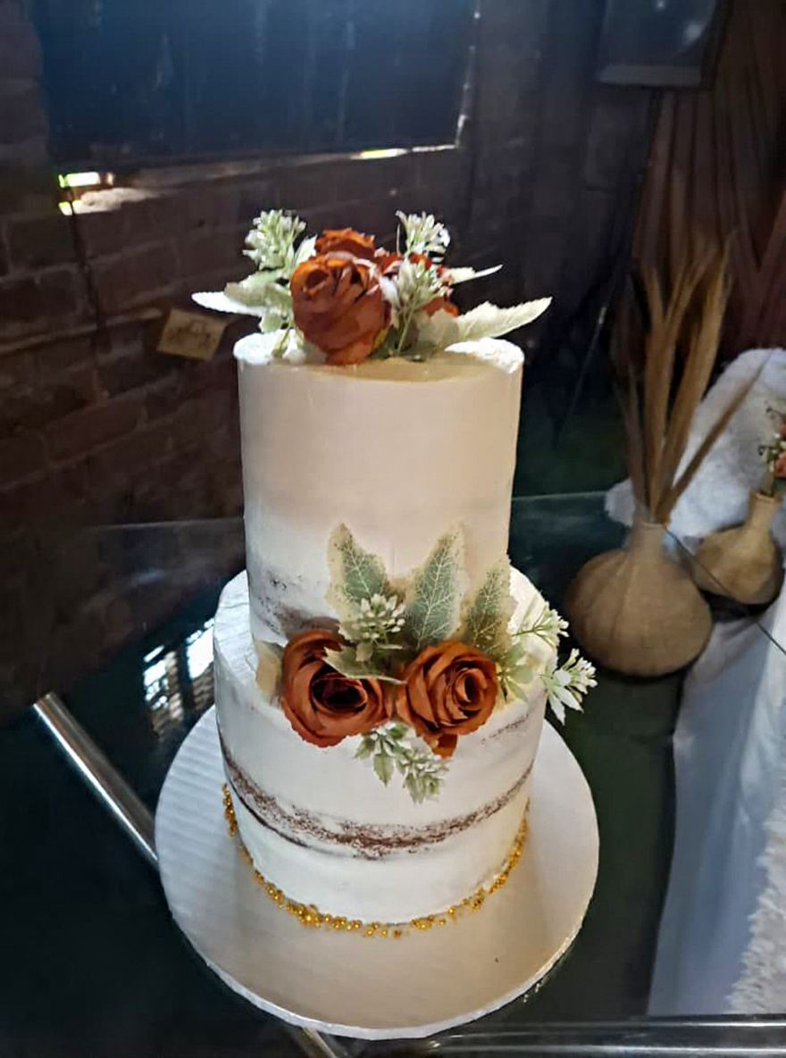 Two-tier semi-naked wedding cake with rust-coloured roses